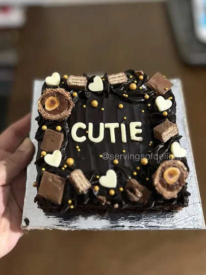 A mini brownie cake for a "Cutie"! This is my classic fudgy brownie, decorated with chocolate frosting, Ferrero Rocher, KitKats, and white chocolate hearts.