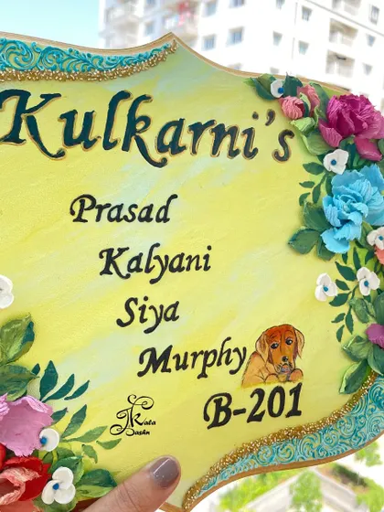 Another angle of the "Kulkarni's" nameplate, focusing on the pet portrait and the upper floral arrangement.