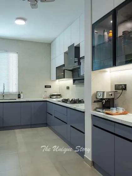 This angle shows the coffee station and the seamless, handle-less design of the cabinets. The combination of matte blue and glossy white finishes creates a sophisticated and contemporary look.