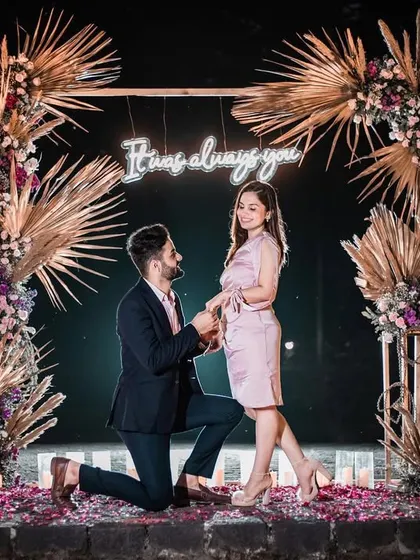 The perfect moment. We create the backdrop for your forever story, like this romantic boho-chic proposal setup complete with a custom neon sign, pampas grass, and the warm glow of countless candles.