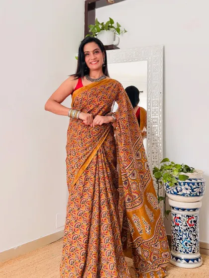 An earthy mustard yellow cotton mulmul saree with a traditional print. This is a perfect saree for daily wear, offering both comfort and ethnic charm.