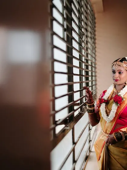 A quiet, contemplative portrait of the bride looking out a window before her wedding ceremony begins.