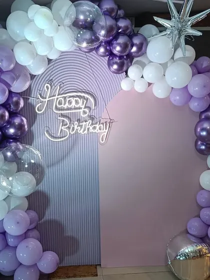 A clean shot of the purple and white balloon arch and backdrop, ideal for birthday photos.