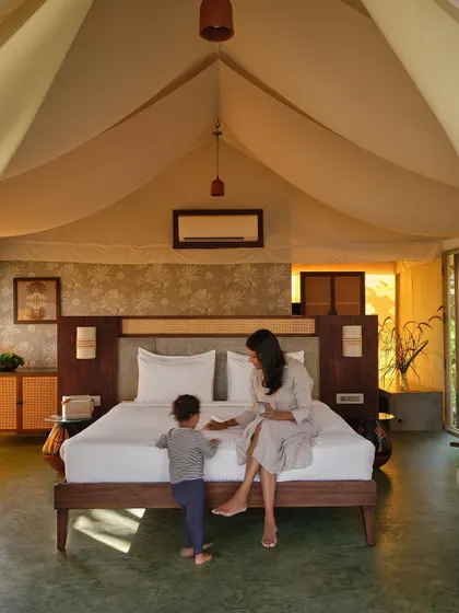 A mother and child share a moment in one of the spacious glamping tents at Fireflies Resort. We design spaces that are not just beautiful, but also functional and comfortable for families to create lasting memories.