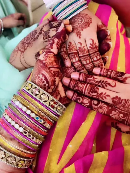A festive Eid photo showing the beautiful stain results on two clients. The colorful bangles make the henna pop.
