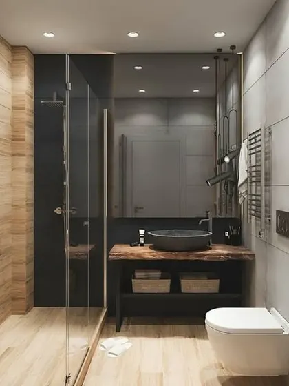 A modern bathroom with a walk-in shower and a mix of dark and light wood-look tiles. The black fixtures provide a contemporary finish.
