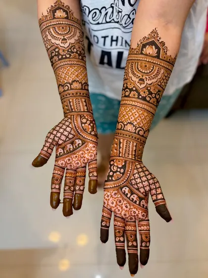 A full view of Nikita's wedding mehendi, with lotus toppers and intricate bands.