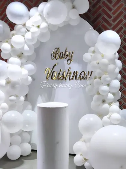 A clean and modern all-white backdrop with gold lettering, perfect for a minimalist and chic baby welcome or shower.