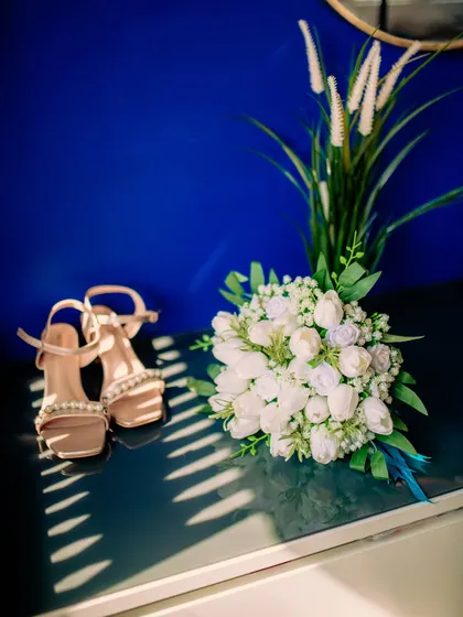 A detail shot of the bride's shoes and bouquet, essential elements of her wedding day attire.