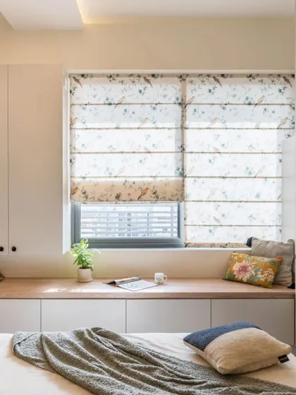 Another example of a beautiful bay window seat, with floral patterned roman blinds adding a touch of charm.