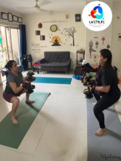 Two clients perform goblet squats in sync, a great functional exercise for building full-body strength. The adjustable dumbbells allow for progressive overload as they get stronger.