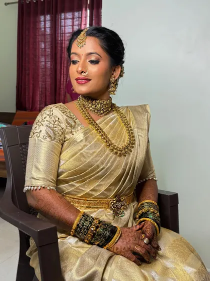 The bride seated, looking elegant and poised. The makeup enhances her features, giving her a regal and timeless look for her reception.