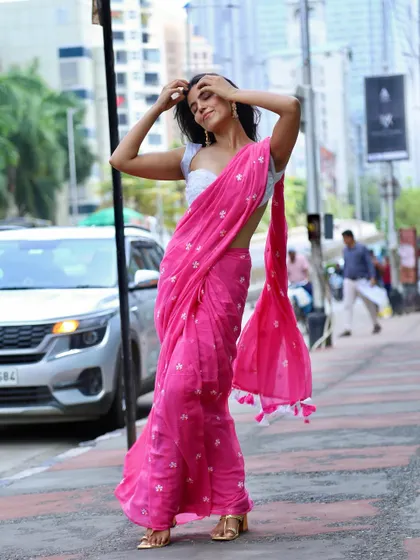 A dynamic shot on a city street, modeling a bright pink embroidered saree. This demonstrates my ability to create striking images in an urban environment.