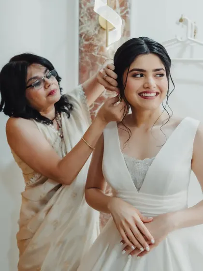 A mother's touch. A beautiful, candid moment as the bride's mother helps with the final details of her elegant hairstyle.
