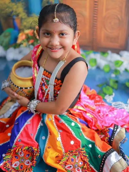 Holding her pot of butter, this little Gopi's sweet smile is infectious. These sibling sessions are filled with so much love and fun.