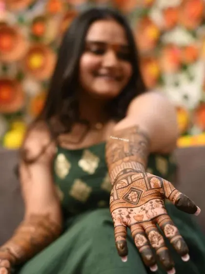 A client showing a close-up of her palm design, with her happy smile in the background.