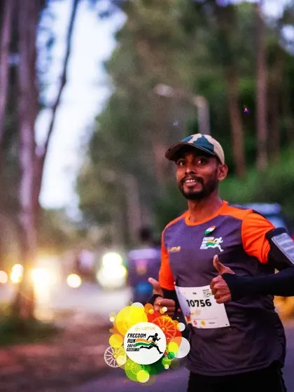An atmospheric shot of a runner during the early morning hours of the Freedom Run, with a thumbs-up for the camera.