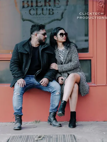 A cool, editorial-style shot of a couple in winter wear posing outside 'The Biere Club' in Bangalore.