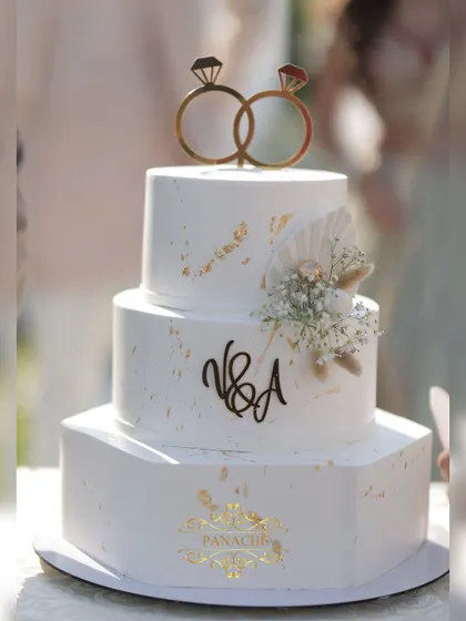 A close-up of the beautiful engagement cake, featuring a custom monogram and delicate floral details.