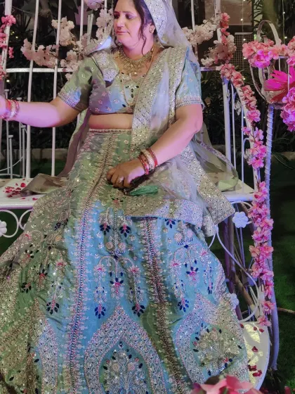 A close-up of the pastel green floral lehenga, showing the detailed embroidery and mirror work.