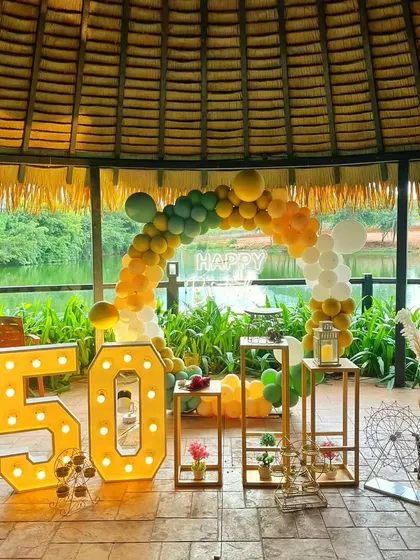 A 50th birthday party set in a beautiful gazebo overlooking the water. The marquee numbers and balloon arch complement the natural scenery perfectly.