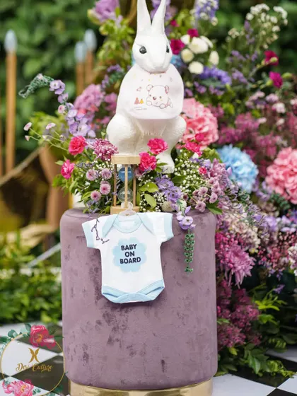 A close-up of the themed details, including a rabbit statue holding a "Baby on Board" onesie, perfectly tying into the baby shower celebration.