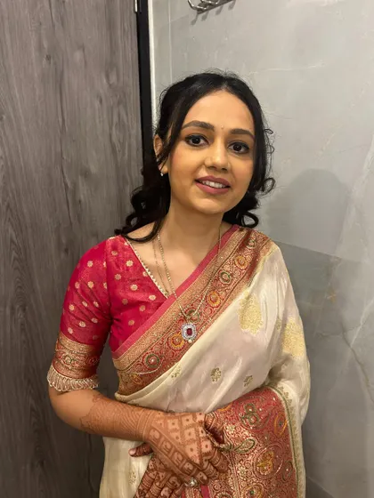 A smiling bridesmaid, happy with her final look. The makeup is fresh and enhances her lovely features.