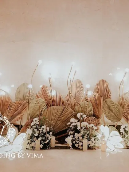 A classic and elegant reception setup symbolizing everlasting love. The stage features a modern, minimalist backdrop with custom monograms, floral arrangements, and soft lighting.