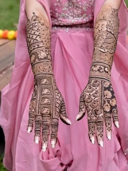 A beautiful example of a full bridal mehandi with a focus on symmetry and clean patterns. The white nails make the dark henna stain pop.