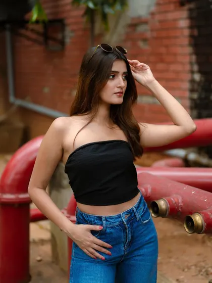A classic fashion portrait with an industrial brick and pipe background. The model's direct gaze and simple styling make this a strong and timeless image.