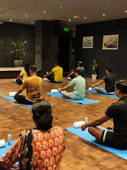 A wide view of a corporate yoga class, showing a spacious and calming setup. I ensure every session, whether on-site or virtual, provides a genuine escape for employees to rejuvenate their minds and bodies.