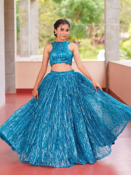 The model twirling to show the full flare of the shimmering teal skirt.