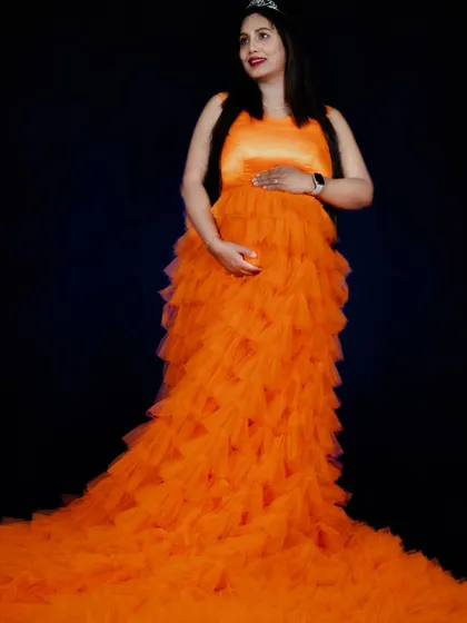 Our orange ruffle gown is vibrant and full of life. The cascading ruffles create a beautiful texture and a long, flowing train for dramatic photos.