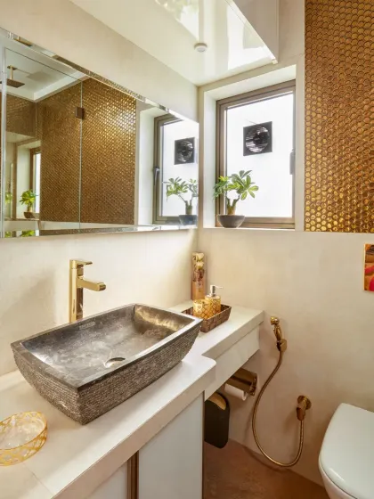 Texture and warmth define this guest washroom. A wall of penny-round gold mosaic tiles creates a stunning, shimmering backdrop. I paired it with a natural stone vessel sink and gold fixtures to create a space that feels both earthy and incredibly luxurious.