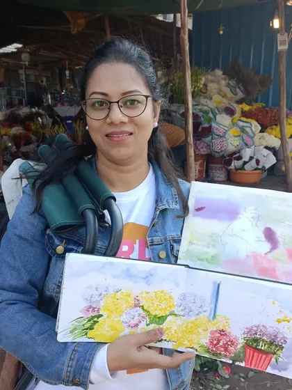Me at the Mehrauli flower market, holding up some of the watercolor sketches from our session. It's a place bursting with color and life, perfect for artists.