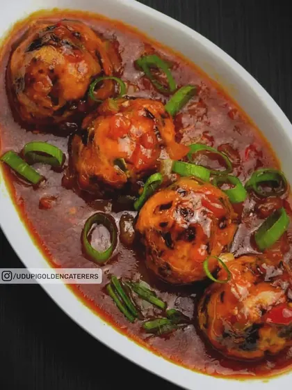 Our Vegetable Manchurian features fried vegetable balls simmered in a savory and tangy Indo-Chinese gravy, garnished with fresh spring onions.