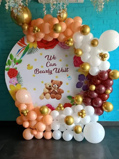 A 'We Can Bearly Wait' teddy bear themed baby shower with a custom backdrop and a balloon arch in warm, neutral tones.