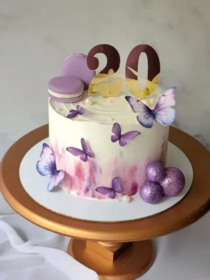 Lavender and purple hues for this 20th birthday cake. The design is simple and elegant, with purple butterflies, macarons, and glittery spheres.
