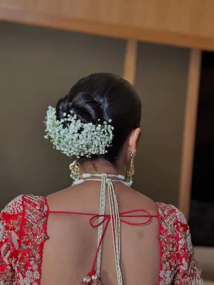 A close-up of a floral bridal updo, showing the texture of the baby's breath.