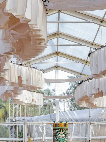 A unique ceiling installation made of undulating white fabric strips, creating a sense of movement and modernity within the rustic theme.