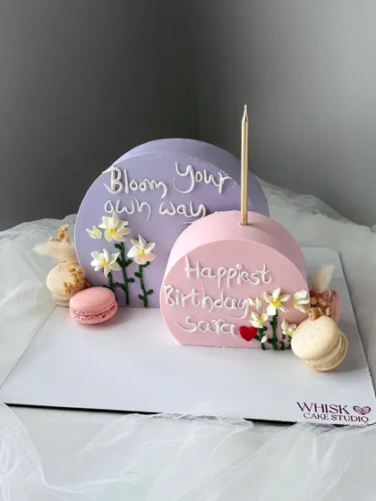 A happy cake to brighten anyone's day. This modern design features two semi-circle cakes with a positive message and delicate flowers.