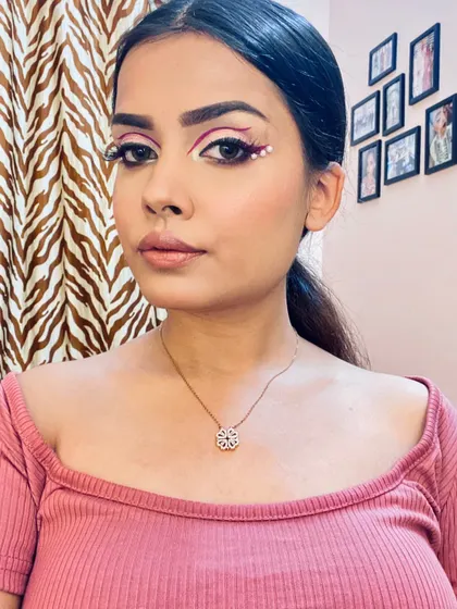 A full-face view of the graphic pink liner look. The eye makeup is the star, while the skin is kept fresh and the lips are a soft, natural shade.