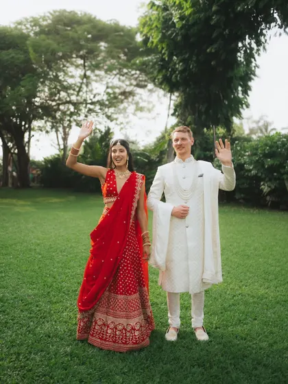 A fun, waving pose from the couple in a lush green setting. It’s a great shot to use for thank you cards.