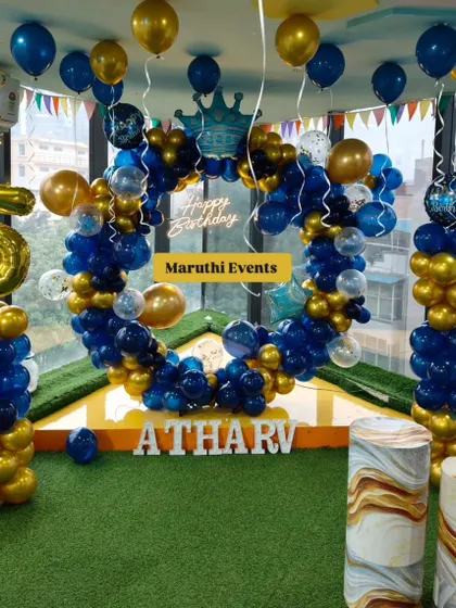 A royal blue and gold themed party for Atharv's 5th birthday. The circular balloon arch is accented with a crown foil balloon and a neon sign.