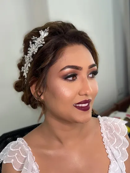 A side view showing the beautiful crystal hair accessory and the soft curls framing her face. This hairstyle is perfect for a modern Christian wedding.