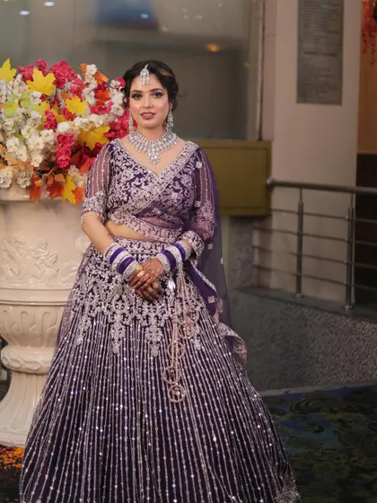 A gorgeous guest in a purple lehenga, with her makeup done to perfection. The look features a smokey eye and a flawless base.