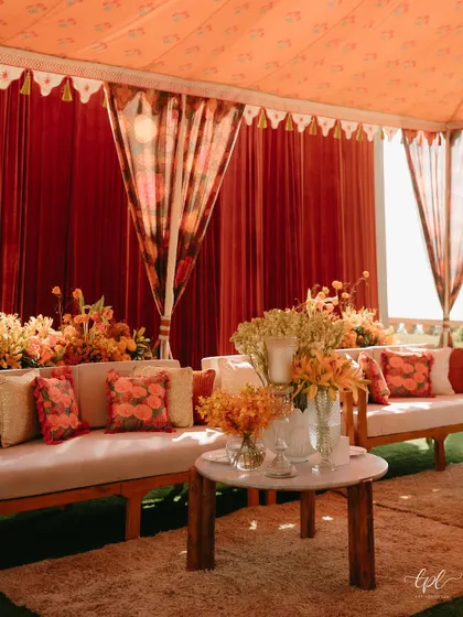 The outdoor setup for the marigold-themed Mehendi, with tassel-fringed umbrellas and custom-printed tablecloths creating a cohesive, festive look.