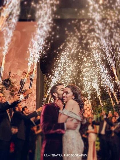 The couple makes a grand entrance to their reception, surrounded by friends holding cold-pyro guns.