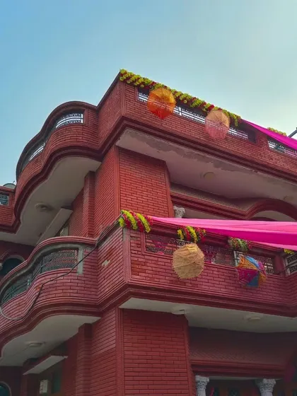 Another view of the red brick house, showing how the pink drapes create a beautiful contrast during the day.