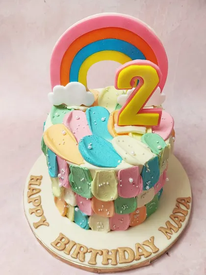 We paint with all the colors of the rainbow on this abstract and artistic birthday cake. Colorful buttercream scales and smudges create a unique texture, topped with a bright rainbow and the number "2" for a vibrant and playful celebration.